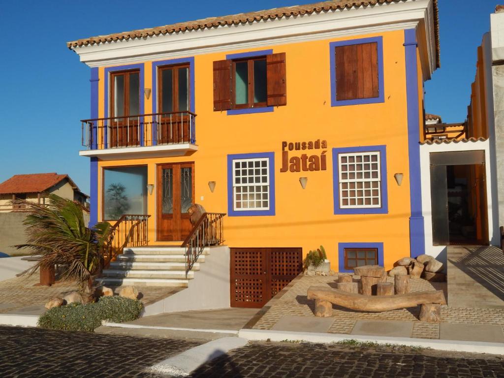 a yellow house with a staircase in front of it at Pousada Jataí in Cabo Frio