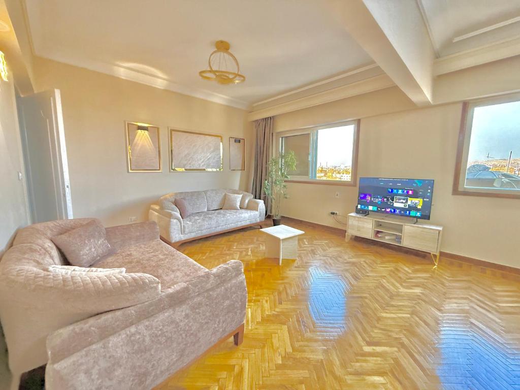 a living room with two couches and a flat screen tv at Golden mile - Downtown Cairo in Cairo