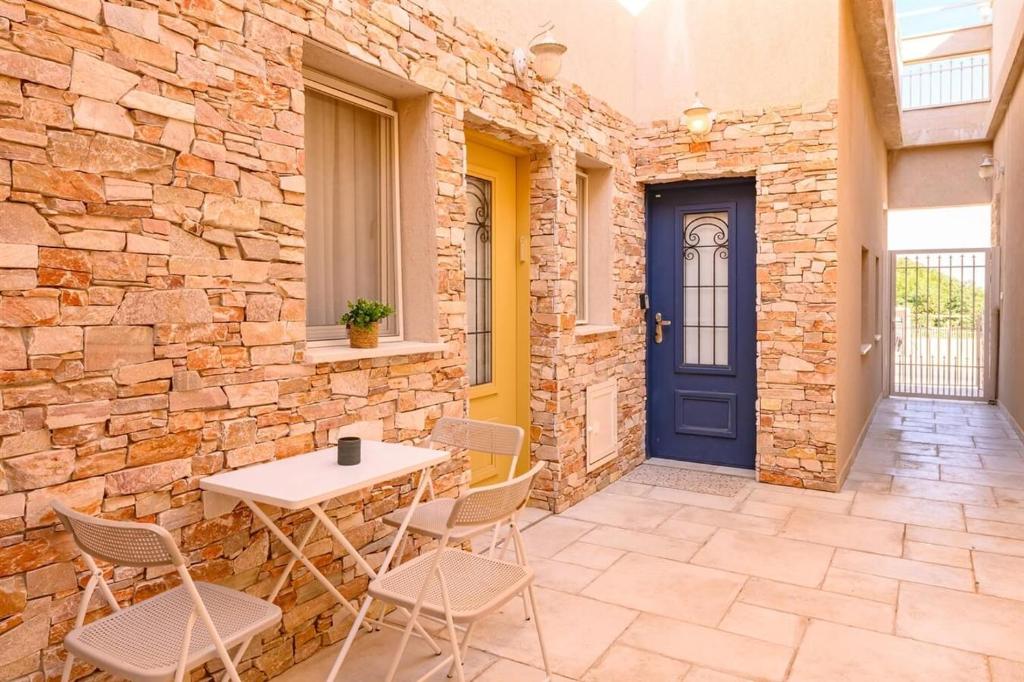 a patio with a table and chairs and a blue door at זוהר על הים - ווילה ו-3 חדרי סטודיו מהממים עם בריכה בנווה זוהר in Neve Zohar