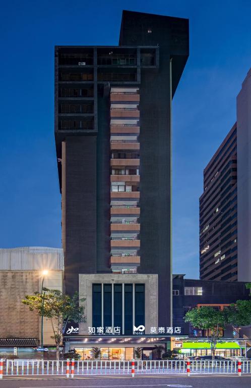 Un edificio alto y negro en una ciudad con en Motel Xiamen Railway Station, en Xiamen
