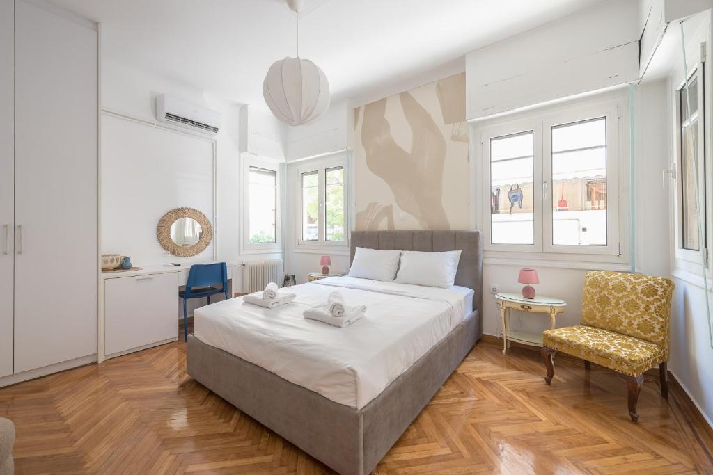a bedroom with a large bed and a chair at Zen Elements, Cozy Guesthouse in City Center in Athens