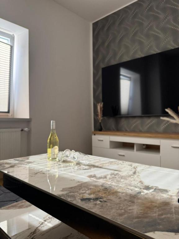 a table with a bottle of wine and a television at Casa del Mondo 3 in Sankt Aldegund
