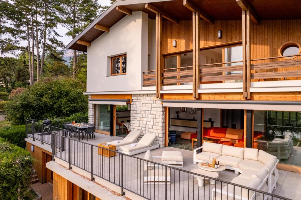 ヴェリエ・デュ・ラックにあるVilla Sarmaz les pieds dans l'eauの白い家具が置かれた大きなデッキのある家