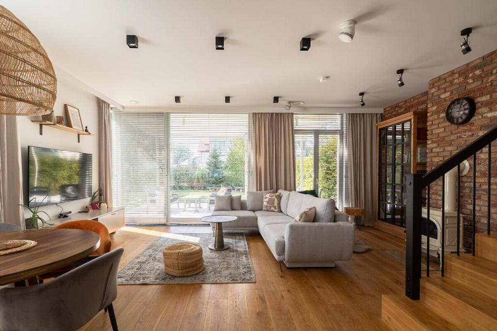 ein Wohnzimmer mit Couch und Tisch in der Unterkunft Warsaw Concierge Konstancin Garden Sauna Yoga in Konstancin-Jeziorna