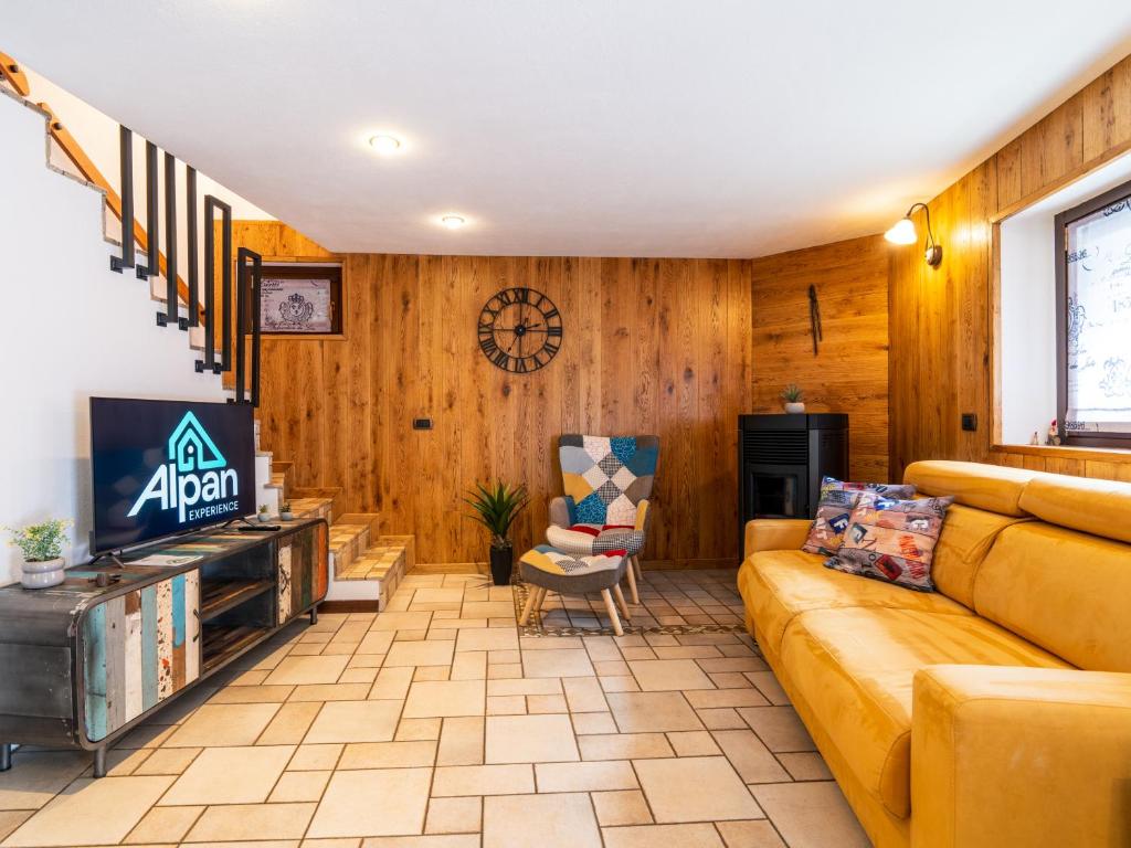 a living room with a couch and a tv at LA CASA DI PIETRA - Relax Home a 10' da Aosta in Roisan