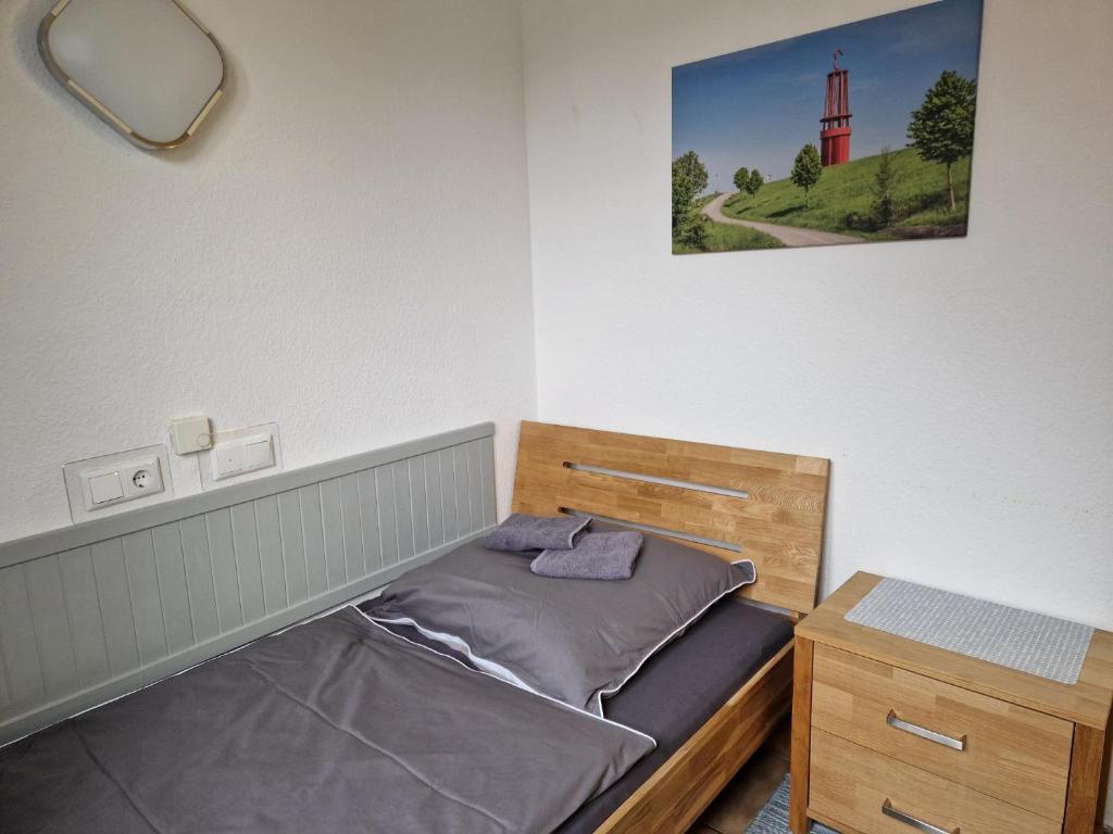 a small bedroom with a bed and a night stand at Pension Moers am Geleucht in Moers