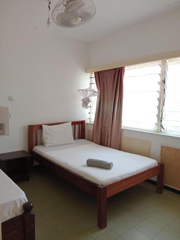 a bed sitting in a room with a window at Kibaki Ocean Front Residence 18 in Mombasa