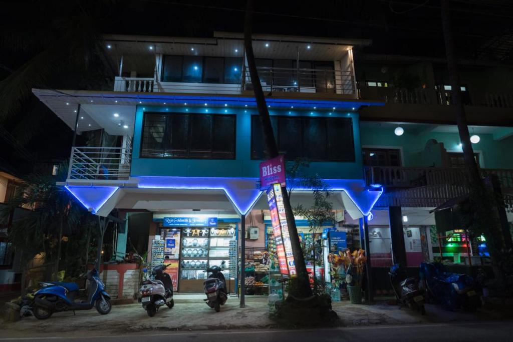 a store with motorcycles parked in front of it at night at Bliss Holiday In in Calangute