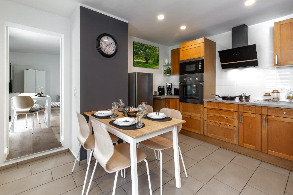 a kitchen with a table with chairs and a clock at Haus am Damm in Pinneberg