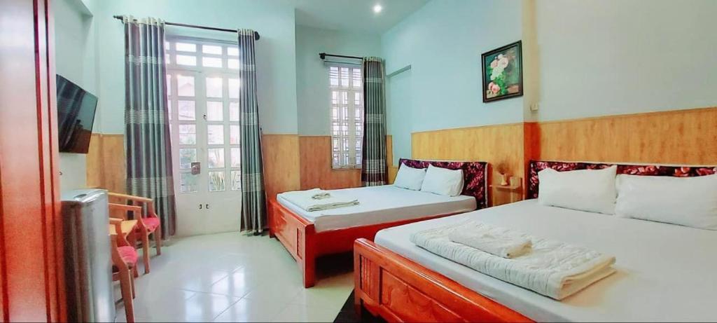 a bedroom with two beds and a window at Khách sạn Ngọc Thủy in Phan Rang