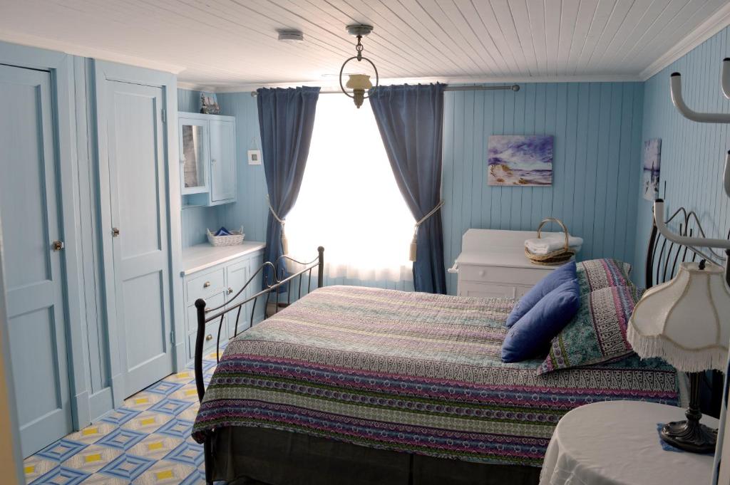 Habitación pequeña con cama y ventana en La Maison entre Mer Montagnes, en Cap-Chat