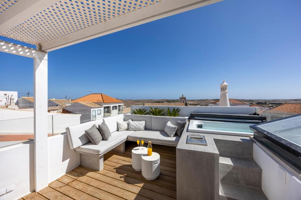 a patio with a couch and a table on a roof at Casa da Praça - Vila do Bispo, Algarve in Vila do Bispo