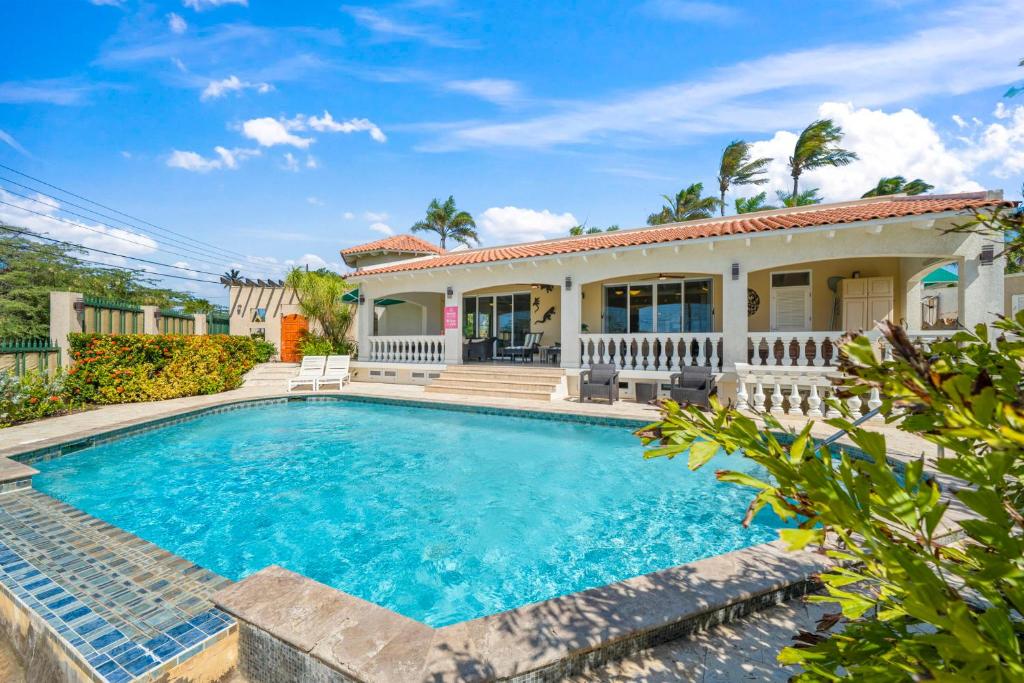 a home with a swimming pool and a house at Boegoeroei 33E in Palm-Eagle Beach