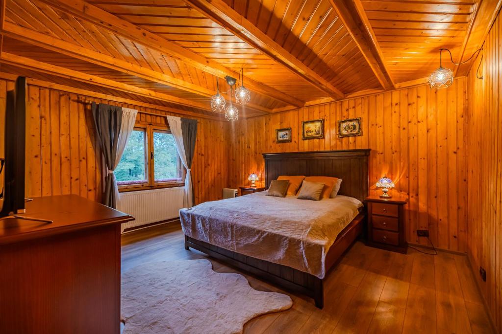 a bedroom with a bed and a wooden ceiling at Cuibul de Munte - Vilă în Breaza in Nistoreşti