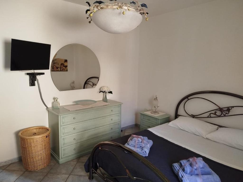 1 dormitorio con cama, espejo y tocador en Musica del Mistral, en Buggerru