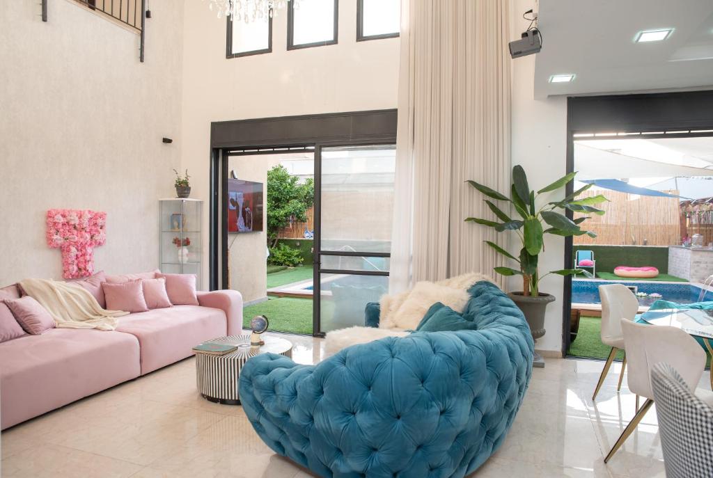 a living room with a large blue ottoman at Chill Villa - וילה מהממת עם בריכה פרטית מחוממת in Ashkelon