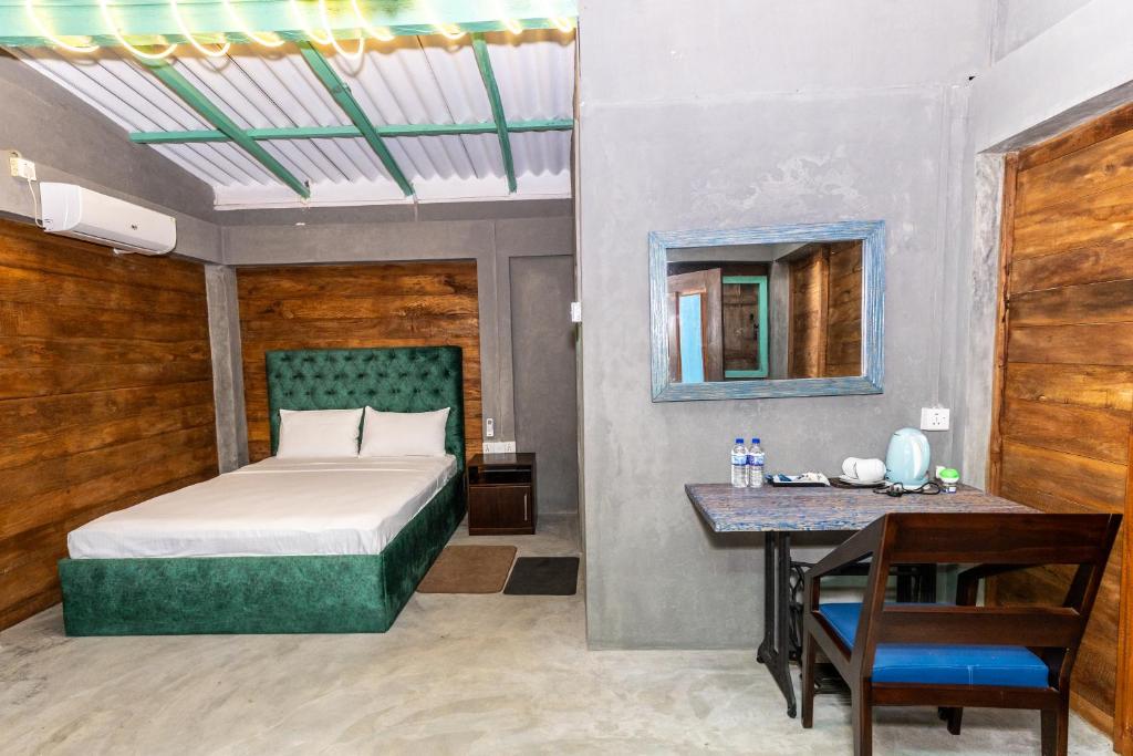 a bedroom with a bed and a table and a mirror at Barramundi in Puttalam