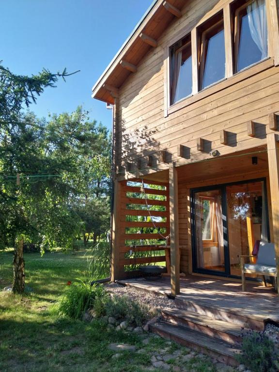 a wooden house with a bench in front of it at Dom Pod Sosnami in Lidzbark