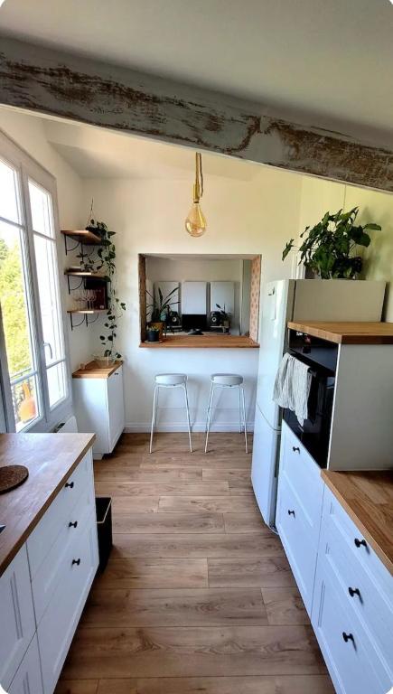 a kitchen with a white refrigerator and a table at Charming apartment bordering Versailles in Buc
