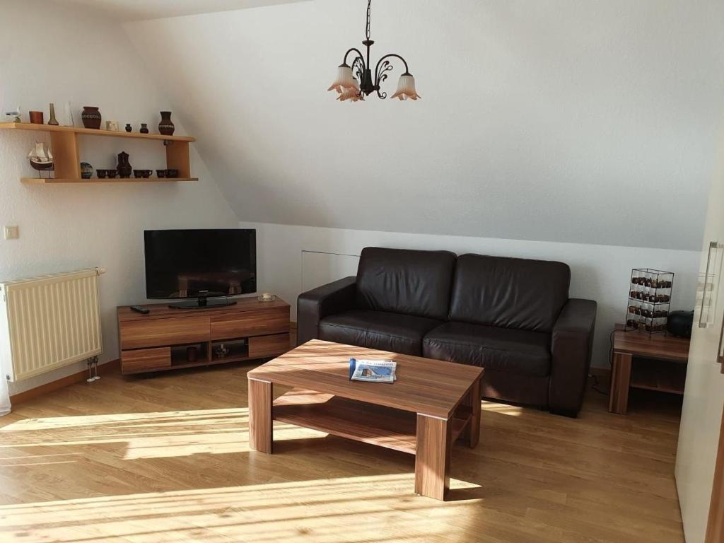 Una sala de estar con un sofá y una mesa de café. en Baltique Fewo 3, en Glowe