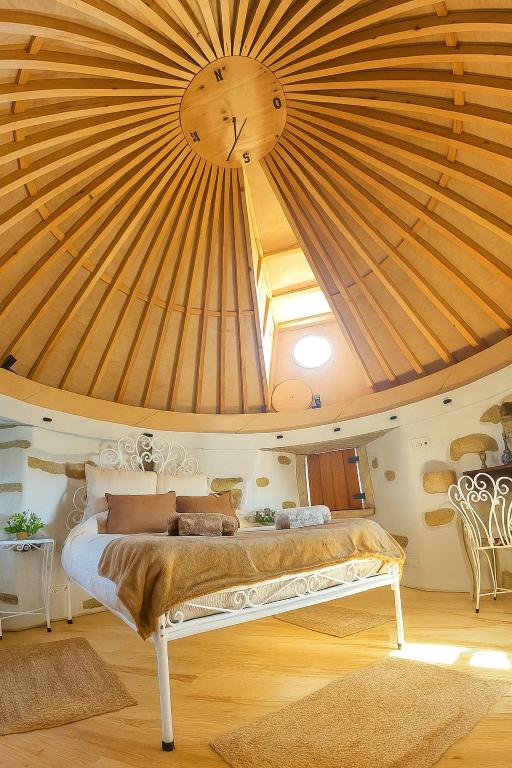 a bedroom with a bed with a wooden ceiling at Moinho das Longas in Montelavar