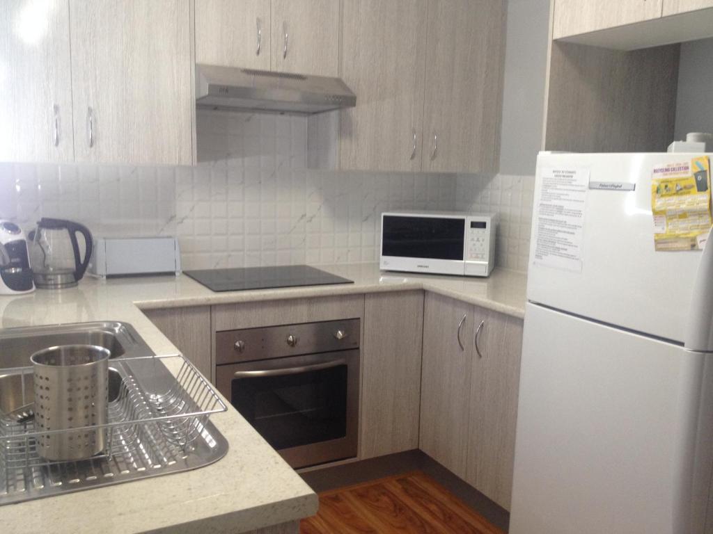 a kitchen with a white refrigerator and a sink at Green Meadow in Nowra