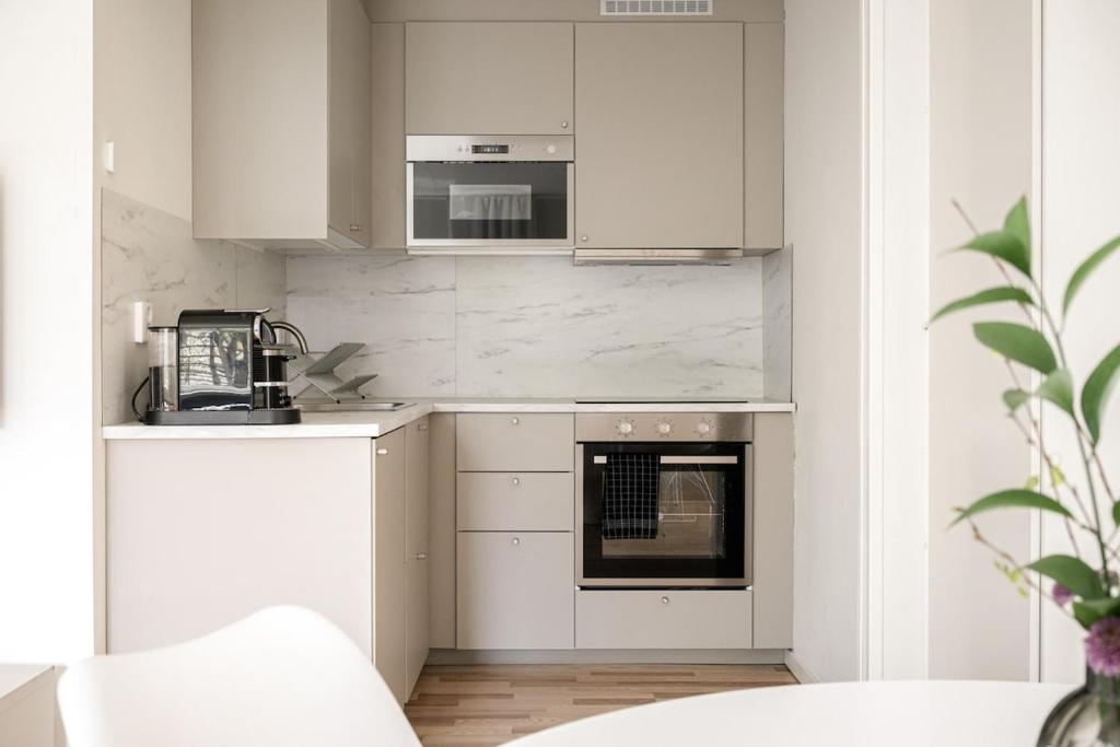 a kitchen with white cabinets and an oven at Nyrenoverad lägenhet med perfekt läge nära Elmia in Huskvarna