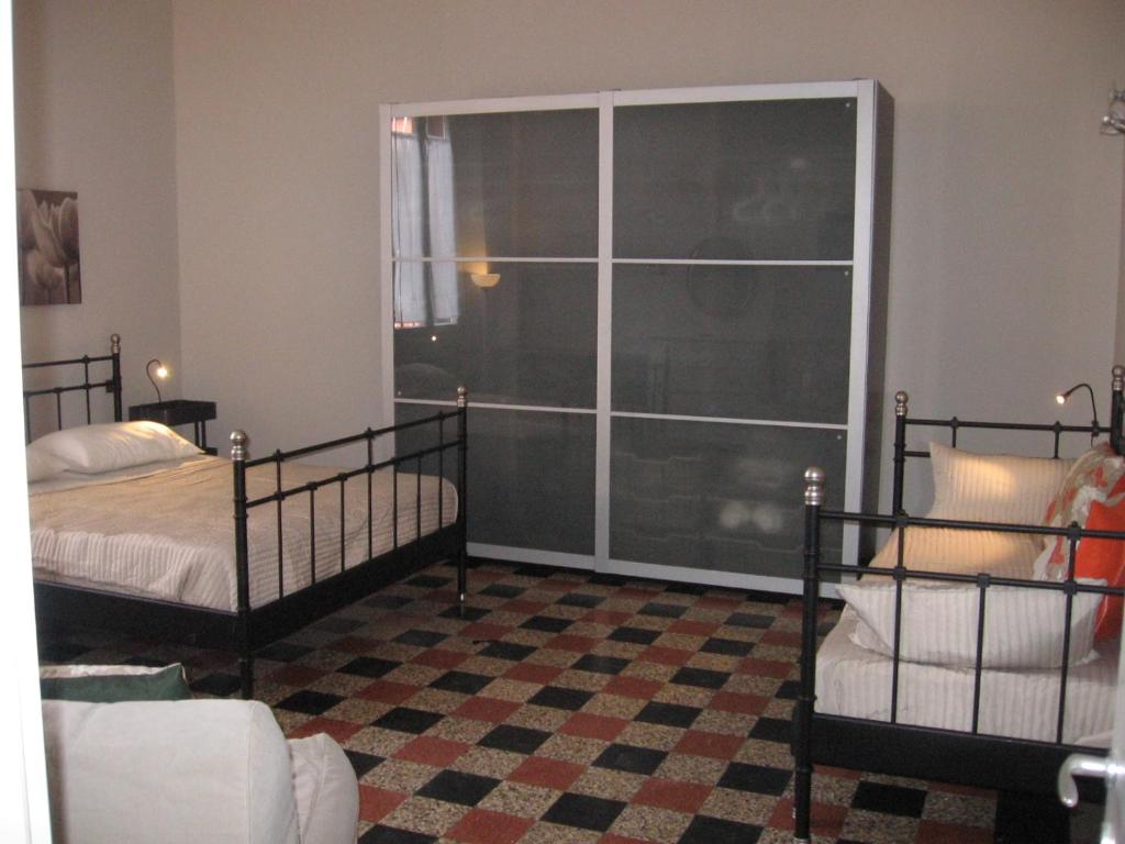 ミラノにあるAppartamento Loretoのベッドルーム1室(ベッド2台、大きな窓付)