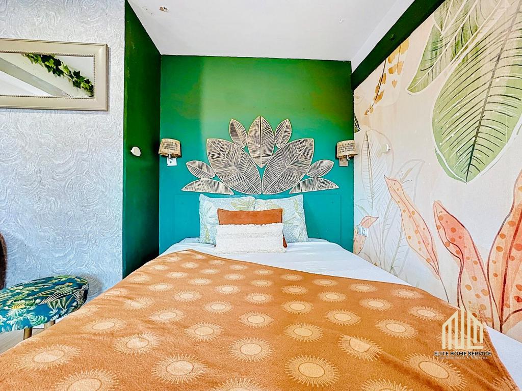 a bedroom with a bed and a green wall at Suite Lou - Chic & Confort in Bray-Dunes