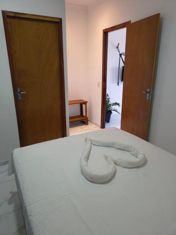 a bed with a white blanket on top of it at Pousada Apart Praia Uruaú in Beberibe