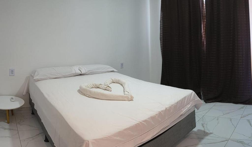 Una cama con una almohada en forma de corazón. en Pousada Apart Praia Uruaú, en Beberibe