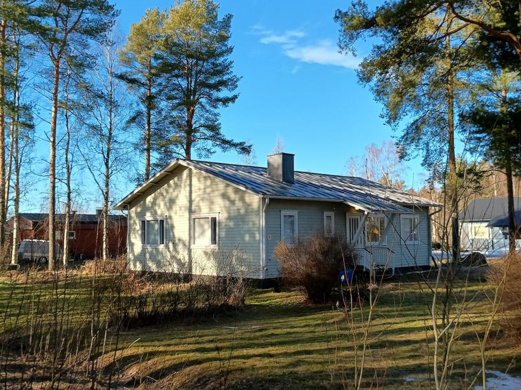 a small white house in the middle of a field at Villa Green in Kruunupyy