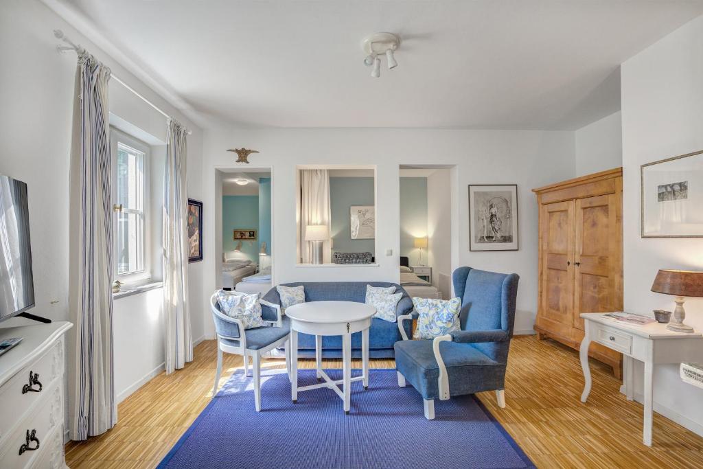 a living room with a table and chairs at Ferienwohnungen Benzenberg in Tutzing