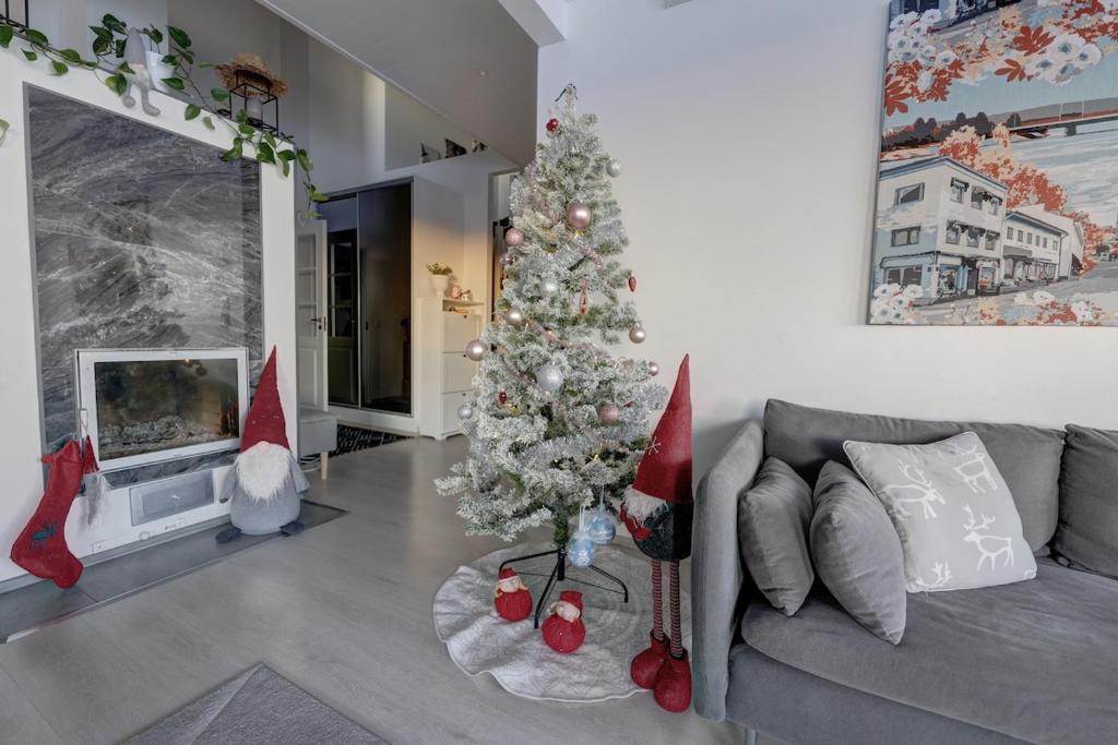a living room with a christmas tree and a couch at VillaApaja in Rovaniemi