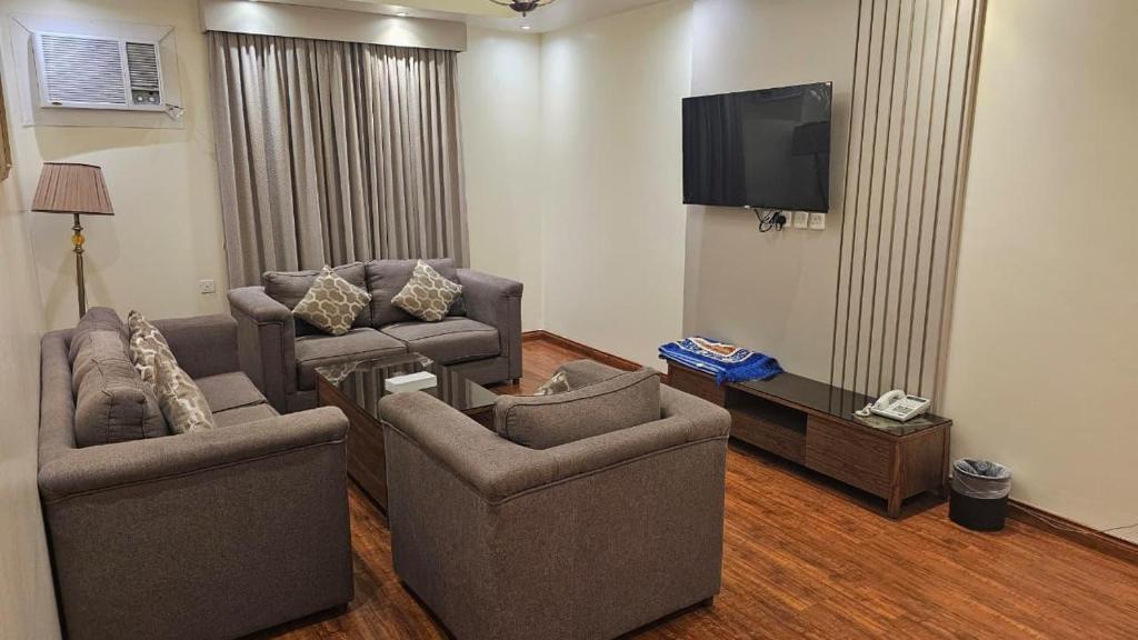 a living room with two chairs and a flat screen tv at ابهى لمار للشقق الفندقيه 2 in Riyadh