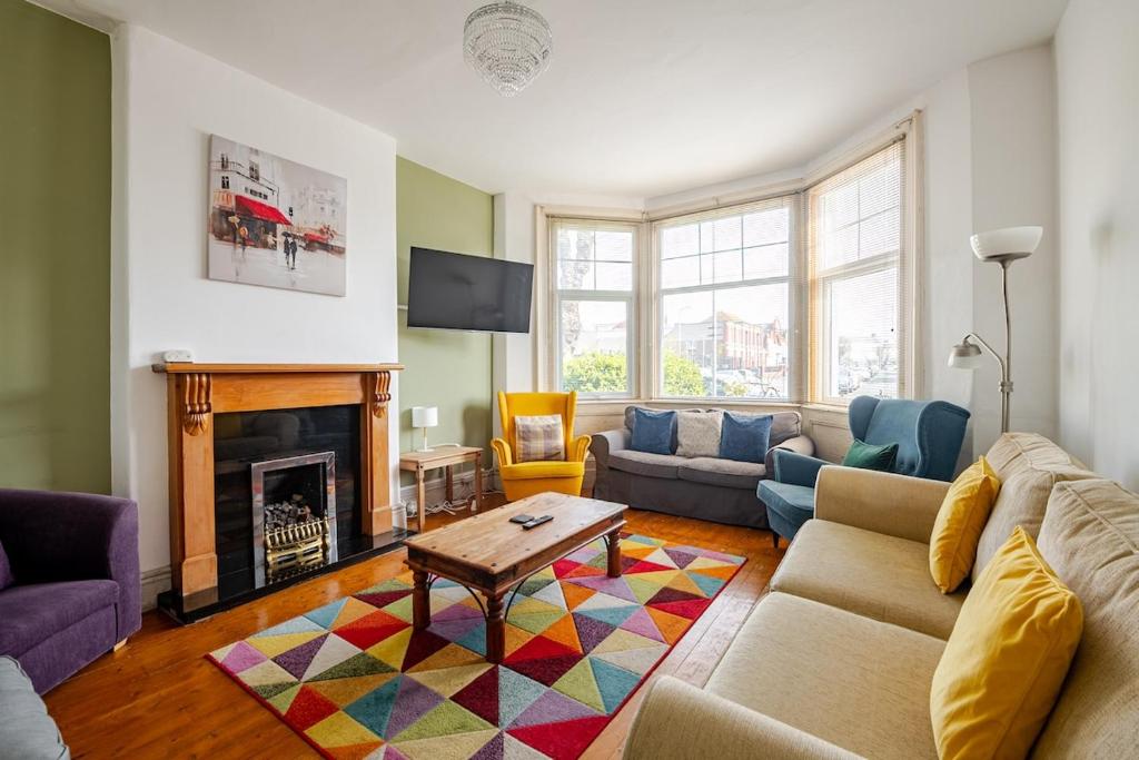 ein Wohnzimmer mit Couch und Kamin in der Unterkunft Victorian Cartref in the heart of Llandudno in Llandudno