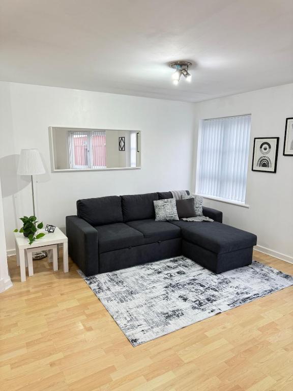 a living room with a black couch and a rug at Stylish 1-BR Apartment Perfect for 4 in Birmingham