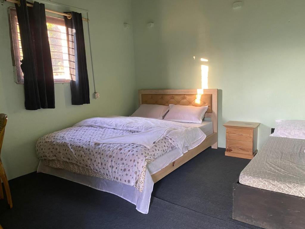 Un dormitorio con una cama grande y una ventana. en Purnata Farm and Arts Residency, en Pokhara