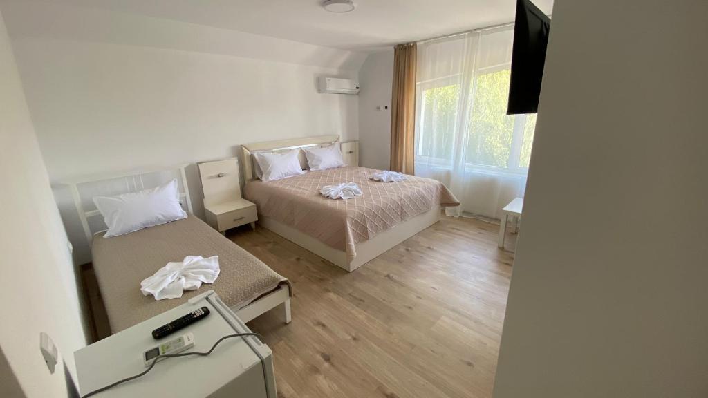 ein Schlafzimmer mit einem Bett und einem Fernseher in der Unterkunft Casa NICORAD Camere in Pucioasa