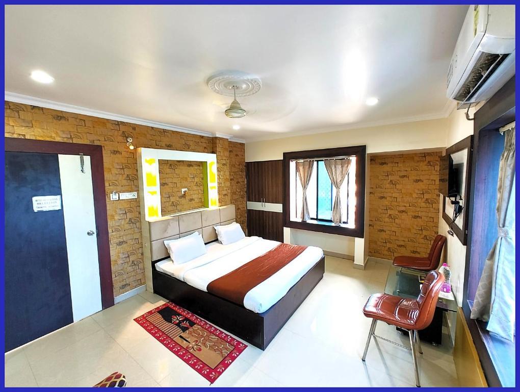 a bedroom with a bed and a chair in it at HOTEL SAI & SAND PIPER Near Jagannath Temple - Restaurant and Parking Facilities - Fully Air Conditioning Hotel - A Top Rated Hotel in Gaya