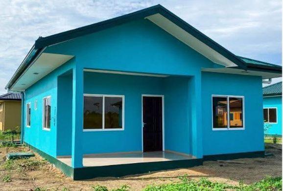 a blue house with a door in a yard at North Area Stay Inn in Paramaribo