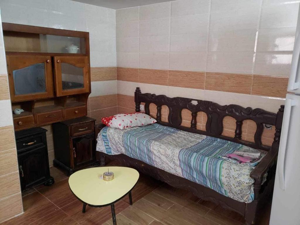 a bedroom with a bed and a table and a tv at Duplexe familiale avec jardin in Hamma Bouziane