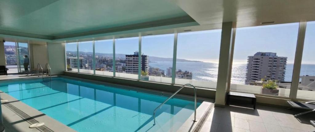 a swimming pool in a building with a view of the ocean at Departamento en Viña del mar cercano a playa, casino de juegos, mall in Viña del Mar