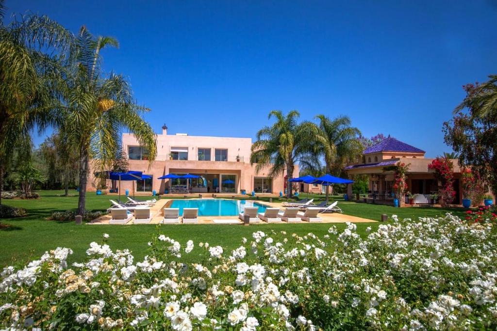 a house with a swimming pool and palm trees at Palais pyar in Najem