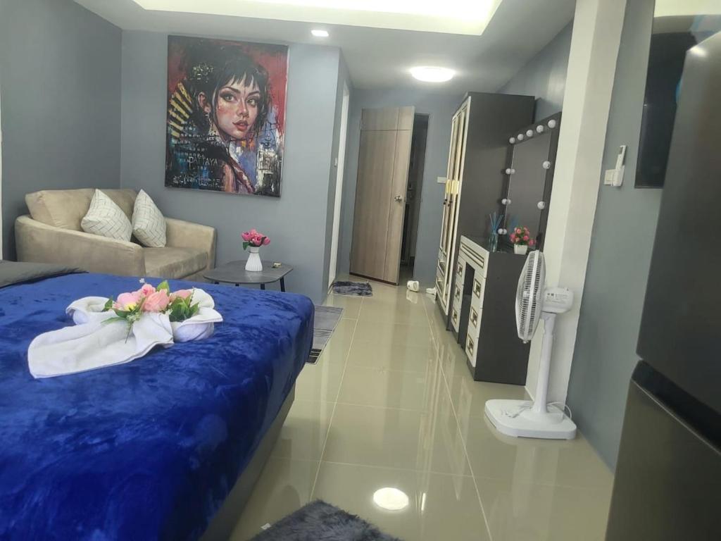 a bedroom with a blue bed with flowers on it at Nirun Condo Pattaya in Ban Nong Chaeng