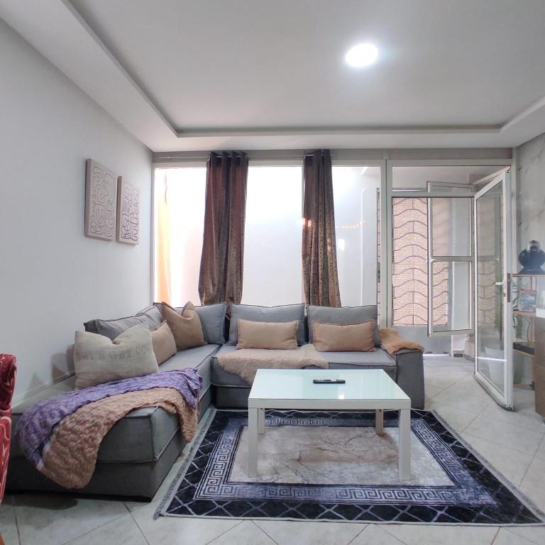 a living room with a couch and a coffee table at joli studio avec terasse au coeur harhoura in Temara