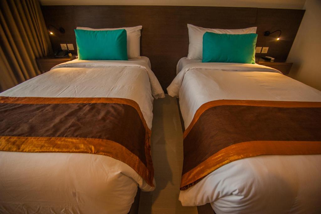 Duas camas individuais num quarto de hotel com colchões em Amed Dream Ibus Beach Club em Amed