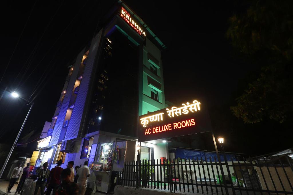 a building with a neon sign in front of it at night at Krishna Residency in Navi Mumbai