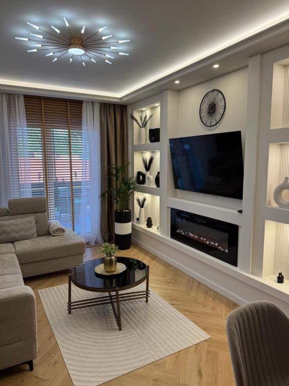 a living room with a couch and a tv at Apartament Anna De Lux z dużym tarasem in Zamość