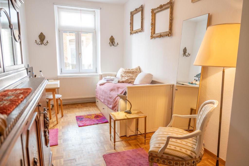 Un dormitorio pequeño con una cama y un escritorio. en Zimmer in Künstlerwohnung, en Stuttgart